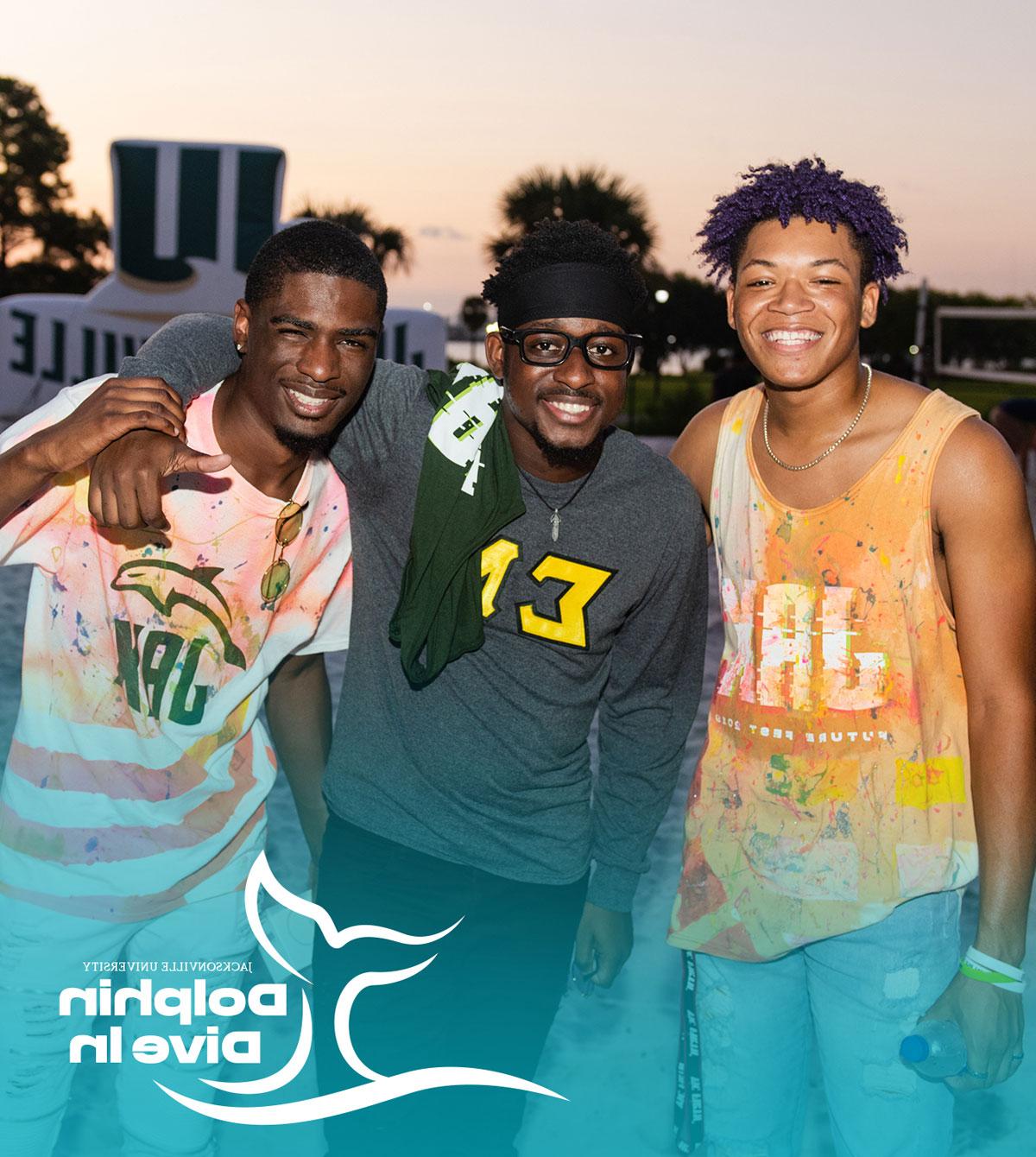 Three students smiling at an on-campus event. 